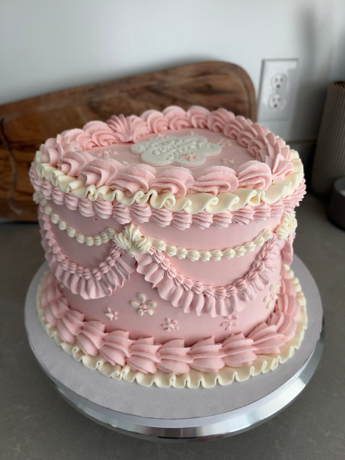 Pink vintage heart-shaped birthday cake with pink and ivory ruffled buttercream