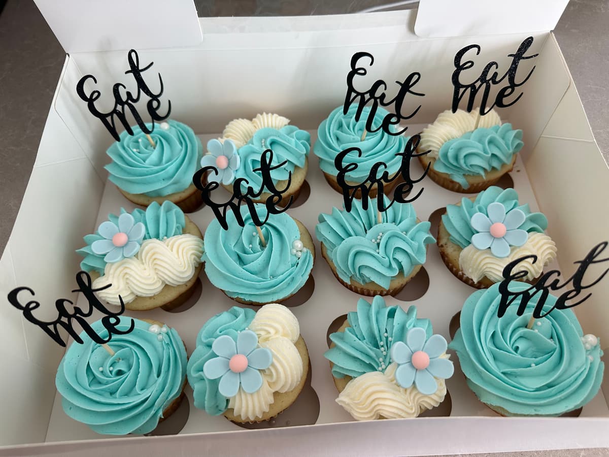 Teal and white cupcakes with Eat Me toppers